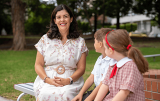 A photo showing Principal Kylie Brakel with two female students
