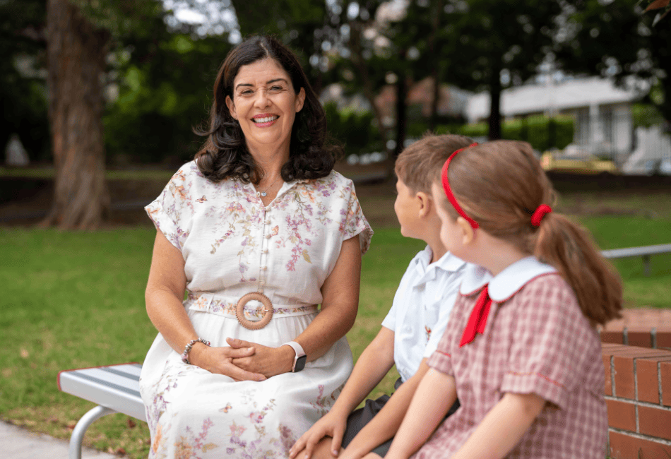 A photo showing Principal Kylie Brakel with two students